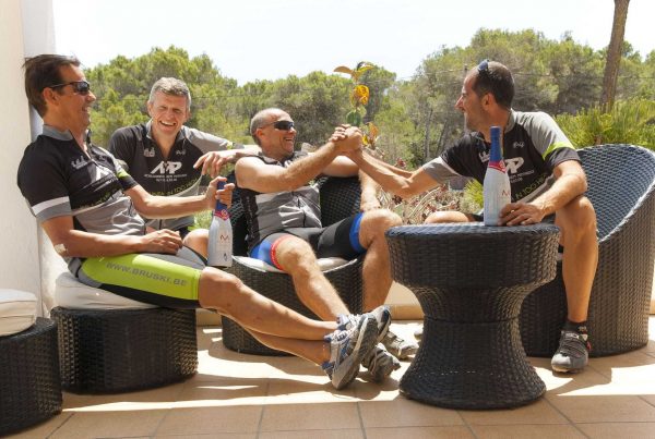 Vier fietsers ontspannen met een drankje op een terras na een fietstocht op Ibiza