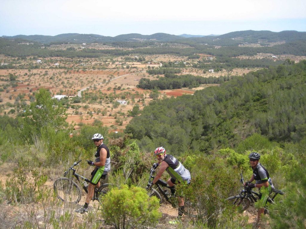 Mountainbikers op een trail met uitzicht over het platteland van Ibiza