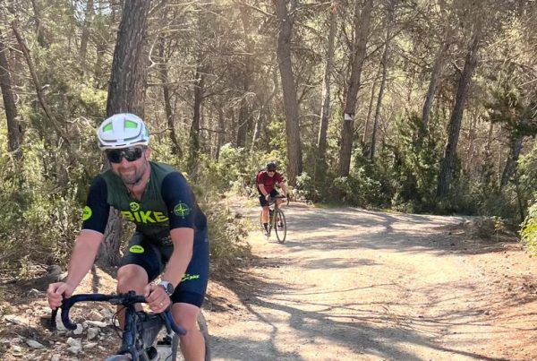 Gravelfietser op een onverharde rode aardeweg door de pijnbossen van Ibiza