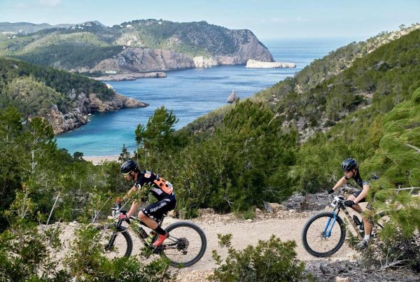 Twee mountainbikers op een trail op Ibiza met uitzicht op de baai – begeleide MTB tour met Bike Ibiza